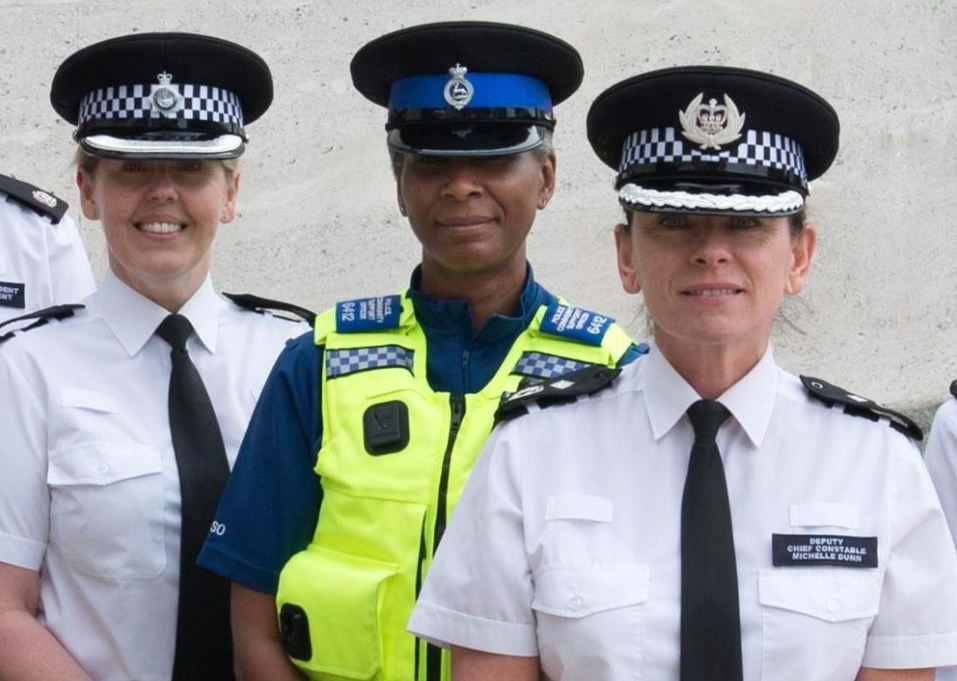 British police uniforms, wearing bulletproof vests over the shirts, and the policewomen's