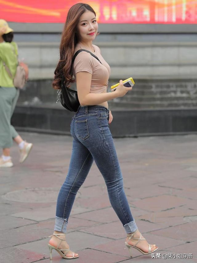 Beautiful women wear tight tops and denim trousers, revealing a small ...