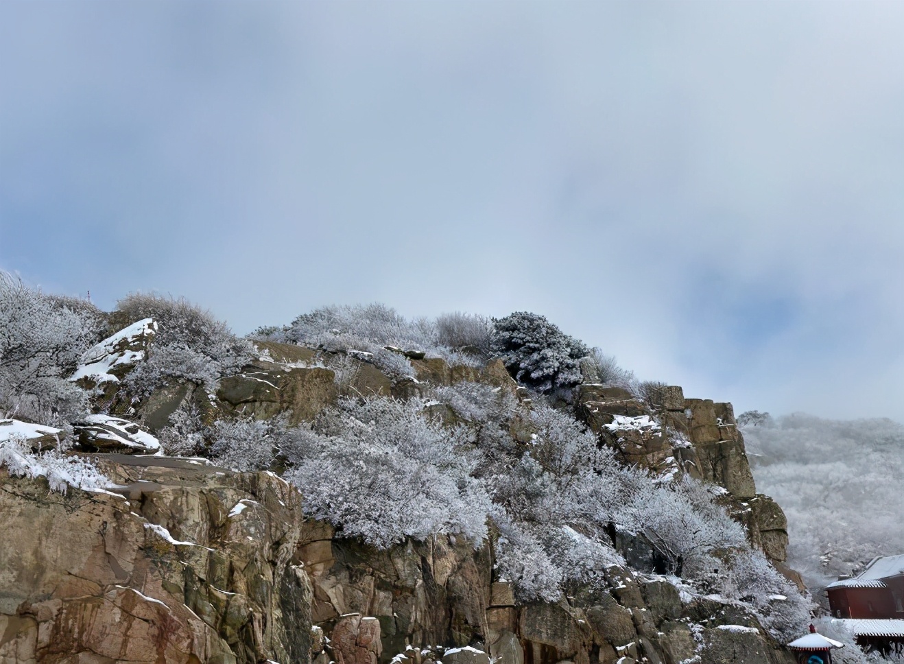 雲煙籠罩下,遠方山黛,近處牆紅,廟簷堆雪,雪凇掛枝.